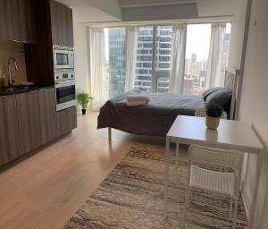 1 dormitorio con cama, mesa y cocina en Toronto Premier INN en Toronto