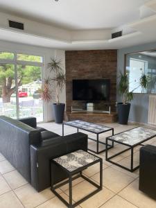 a living room with a couch and tables and a tv at Hotel Kalloni in Volos