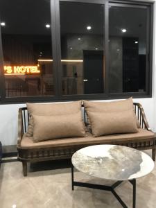 un sofá con almohadas y una mesa en una habitación en The MC hotel mộc châu, en Mộc Châu