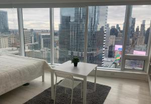 a bedroom with a table and a view of a city at Toronto Premier INN in Toronto