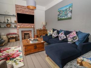 a living room with a blue couch and a fireplace at Stone's Throw in Budleigh Salterton