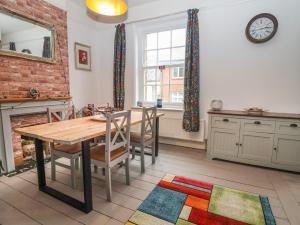 a dining room with a table and chairs and a fireplace at Stone's Throw in Budleigh Salterton