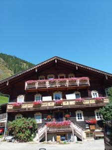 budynek z kwiatami na balkonach w obiekcie Obenfigerhof w Kals am Großglockner