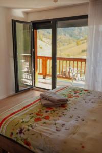 a bedroom with a bed with a view of a balcony at Bujtina e Gjyshes in Peje