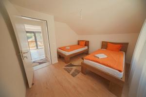 a small bedroom with two beds and a window at Bujtina e Gjyshes in Peje