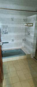 a bath tub in a bathroom with a tiled floor at Kafka Gardens in Kisumu