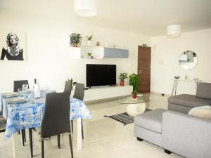 uma sala de estar com uma mesa, um sofá e uma televisão em Seaview-CasadiAlfio-Qawra em St. Paul's Bay