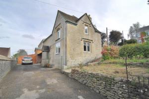 uma velha casa de tijolos com um carro estacionado numa garagem em Trade Digs - Contractors Accommodation - Stroud 