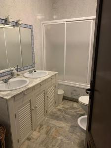 a bathroom with two sinks and a toilet at Casa Moya Villa Lujo in Alájar +16 photos