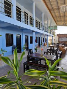 un patio al aire libre con mesas y sillas y un edificio en Buenas Pension House en Puerto Princesa