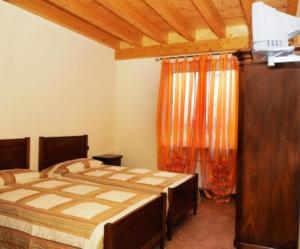 una camera da letto con un grande letto con una tenda arancione di Agriturismo Parco Del Chiese a bedizzole