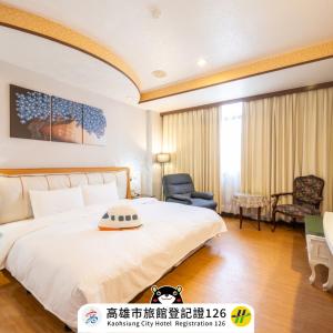 a bedroom with a large white bed and a chair at Wenpin Hotel - Pier 2 in Kaohsiung