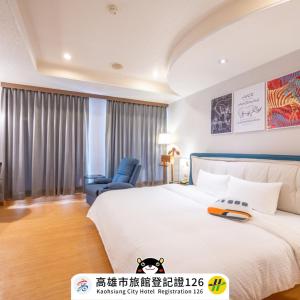 um quarto de hotel com uma cama e uma cadeira em Wenpin Hotel - Pier 2 em Kaohsiung