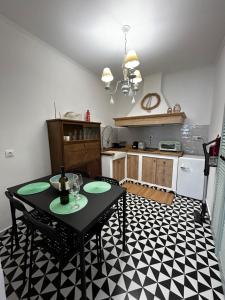 a kitchen with a black table and a black and white floor at Homefeel2024 in Kavála