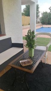 una maceta sentada sobre una mesa en un patio en Villa Marichu. Piscina, BBQ y a 15 min Puy du Fou, en Totanés