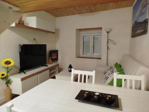 a living room with a table and a tv at Berrocal de Aldea en Cabo in Aldeaencabo de Escalona