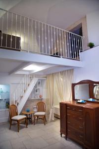 una sala de estar con una escalera y una habitación con sillas en Cummersa Mazzini casa tipica nel Centro storico DI Locorotondo, en Locorotondo
