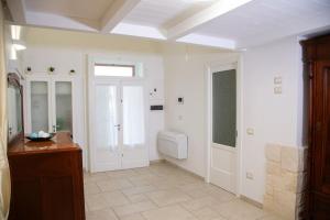 baño blanco con aseo y ventana en Cummersa Mazzini casa tipica nel Centro storico DI Locorotondo, en Locorotondo