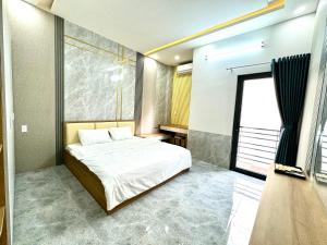 sypialnia z dużym łóżkiem i oknem w obiekcie TONY HOMESTAY CẦN THƠ w mieście Cần Thơ