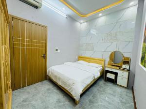 a bedroom with a bed and a mirror and a door at TONY HOMESTAY CẦN THƠ in Can Tho