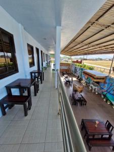 un balcón con mesas y bancos en un edificio en Buenas Pension House en Puerto Princesa