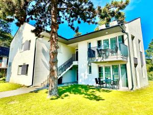 a house with a tree in front of it at Ady Corner Prémium Apartmanok - Siófok in Siófok