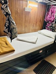 a pair of beds in a small room at New Mahira Dormitory in Mumbai