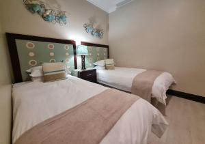 a hotel room with two beds with white sheets at Zimbali KJ01 4 Bedroom Home in Ballito
