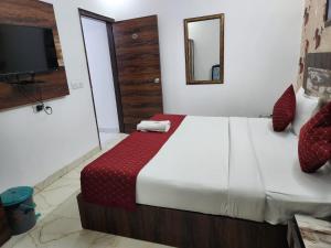 a bedroom with a large bed and a television at Hotel Delhi 37 Ambience Near IGI Airport in New Delhi