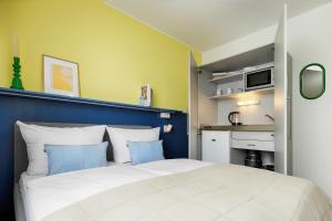 a bedroom with a large white bed with blue walls at MaxAparthotel by homekeepers in Fürth
