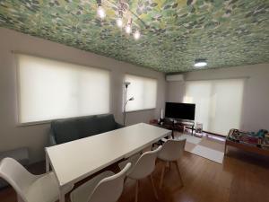 Zimmer mit einem Tisch und Stühlen sowie einem TV in der Unterkunft Kisarazu - House - Vacation STAY 06328v in Kisarazu