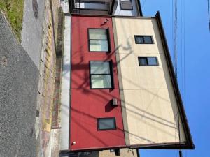 ein hohes rotes Gebäude mit einem Schatten auf der Seite in der Unterkunft Kisarazu - House - Vacation STAY 06328v in Kisarazu
