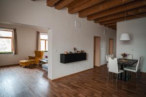 a dining room and living room with a table and chairs at Farma Tasov in Velké Meziříčí