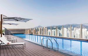 a balcony with a swimming pool on top of a building at ALVA HOTEL BY ROYAL in Hong Kong