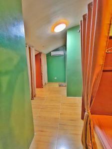 an empty room with green walls and wooden floors at Aashvi Cozy Cabin Hostel near Mactan Airport in Pusok
