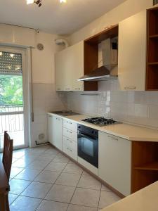 塞里亞泰的住宿－Flor，厨房配有白色橱柜和炉灶烤箱。