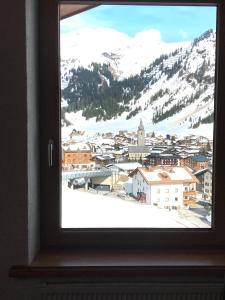 a view of a snowy mountain from a window at Hotel Schranz in Lech am Arlberg