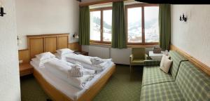 a hotel room with a bed and a couch at Hotel Schranz in Lech am Arlberg