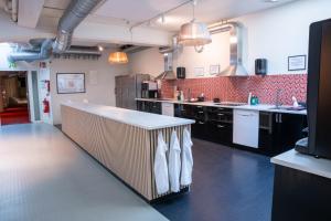 duża kuchnia z czarnymi blatami i białymi urządzeniami w obiekcie Stockholm Hostel w Sztokholmie