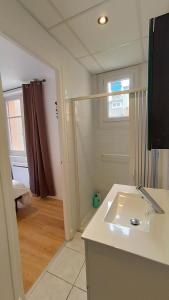 La salle de bains est pourvue d'un lavabo et d'une fenêtre. dans l'établissement Foucault - Appartements - au cœur de Lourdes, à Lourdes