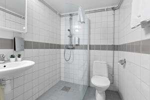 a white bathroom with a toilet and a sink at Forenom Hotel Kista in Stockholm