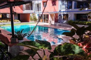 a swimming pool in front of a building at Golden 8 Airport Hostel - Mactan Cebu in Pusok