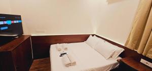 mały pokój z łóżkiem z ręcznikami w obiekcie Chippy Inn w mieście Ćennaj
