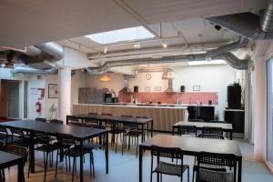 una sala con tavoli e sedie e una cucina di Stockholm Hostel a Stoccolma