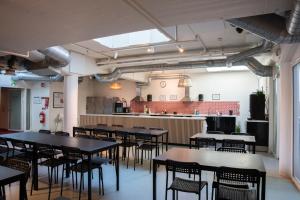 a room with tables and chairs and a kitchen at Stockholm Hostel in Stockholm