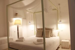a bedroom with a white canopy bed with a lamp at Palmieri Luxury Rooms in Gallipoli