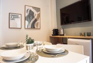 una mesa de comedor con tazones y platos blancos. en Downtown Perugia - apartment with a cozy terrace en Perugia