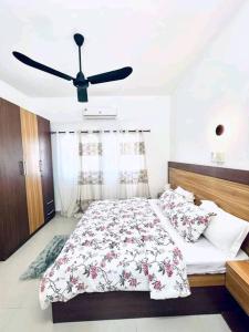 Schlafzimmer mit einem Bett und einem Deckenventilator in der Unterkunft Villa Pékin-kirikou in Cotonou