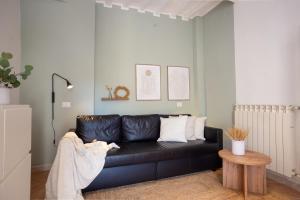 ein Wohnzimmer mit einem schwarzen Ledersofa in der Unterkunft Downtown Perugia - apartment with a cozy terrace in Perugia