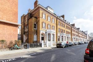 a row of buildings on a street with parked cars at Urban Living - 2Bed 2Bath in South Kensington in London